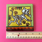 Talavera tile with cat holding skeleton fish