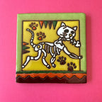 Talavera tile of skeleton cat holding skeleton fish in mouth