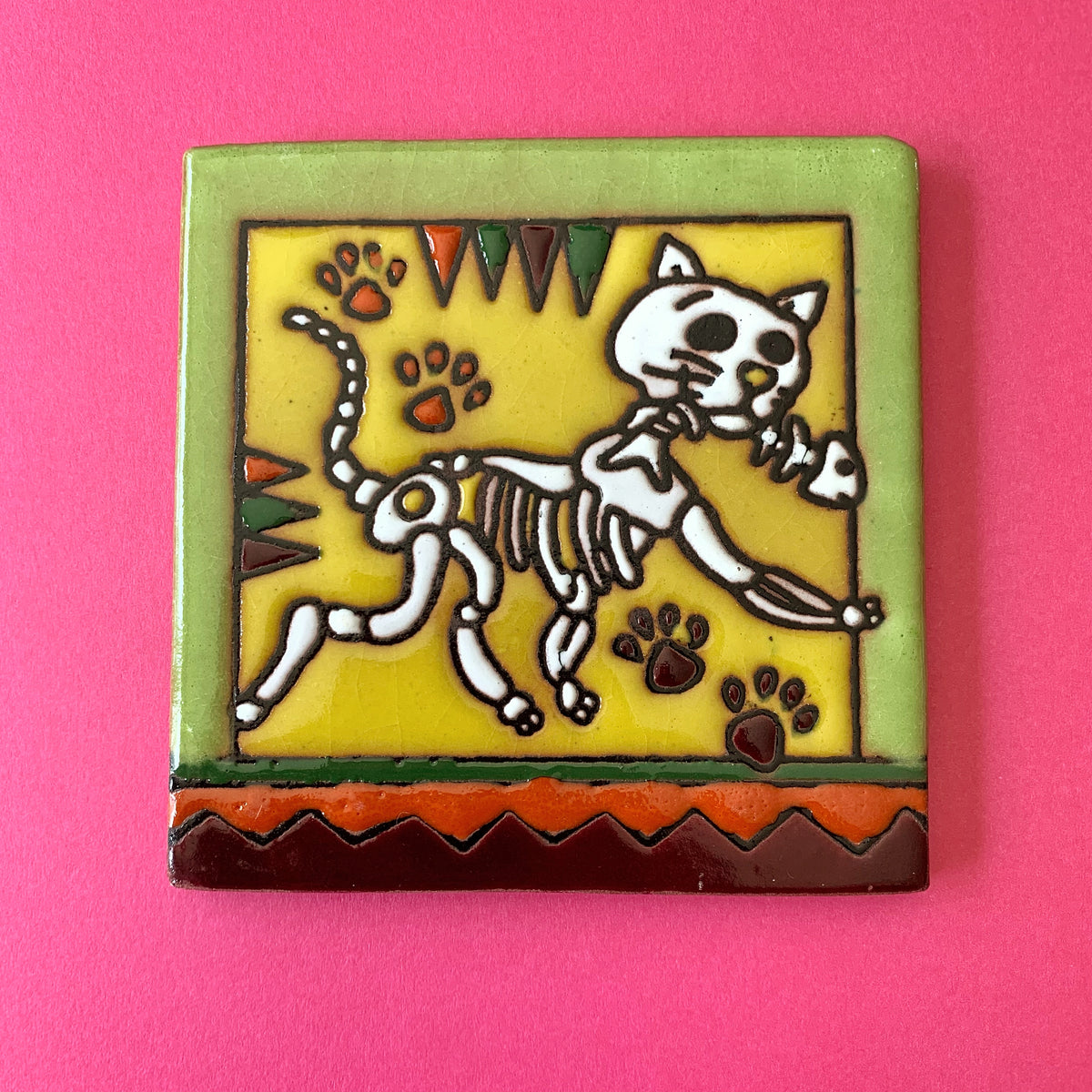 Talavera tile of skeleton cat holding skeleton fish in mouth